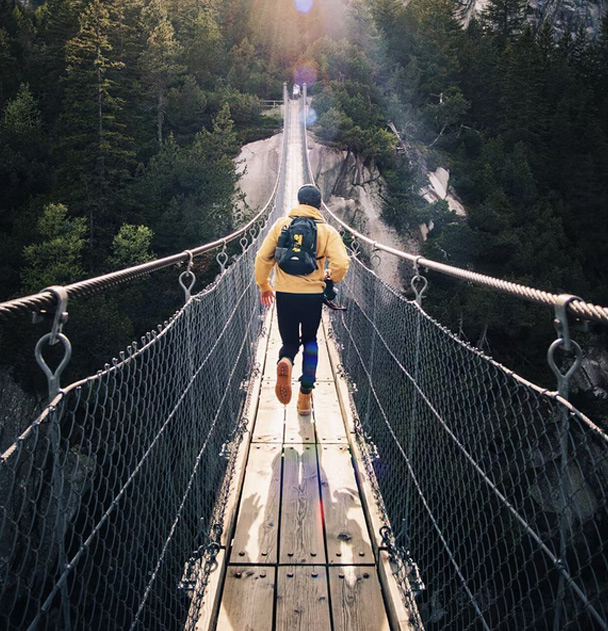 A person runs across a suspension bridge to represent how anxiety can impact your life. Online anxiety therapy in San Francisco and Los Angeles can help your find your way.