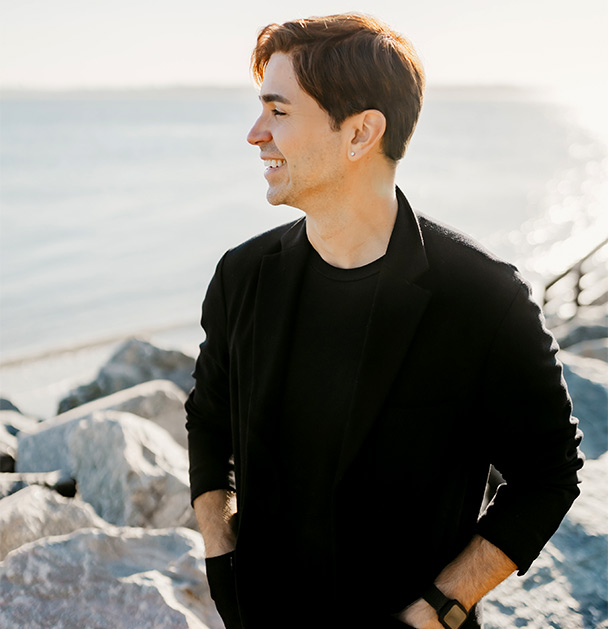 Dr. Nathan Brandan smiles at the beach. Dr. Nathan uses an affirmative therapy approach to online LGBTQ+ counseling in San Francisco and Los Angeles so you feel supported and heard.