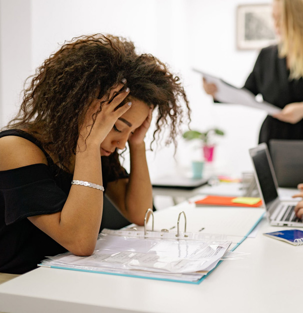 A woman holds her head in her hands. This image is to represent someone dealing with anxiety and how anxiety therapy in San Francisco and Los Angeles may help.